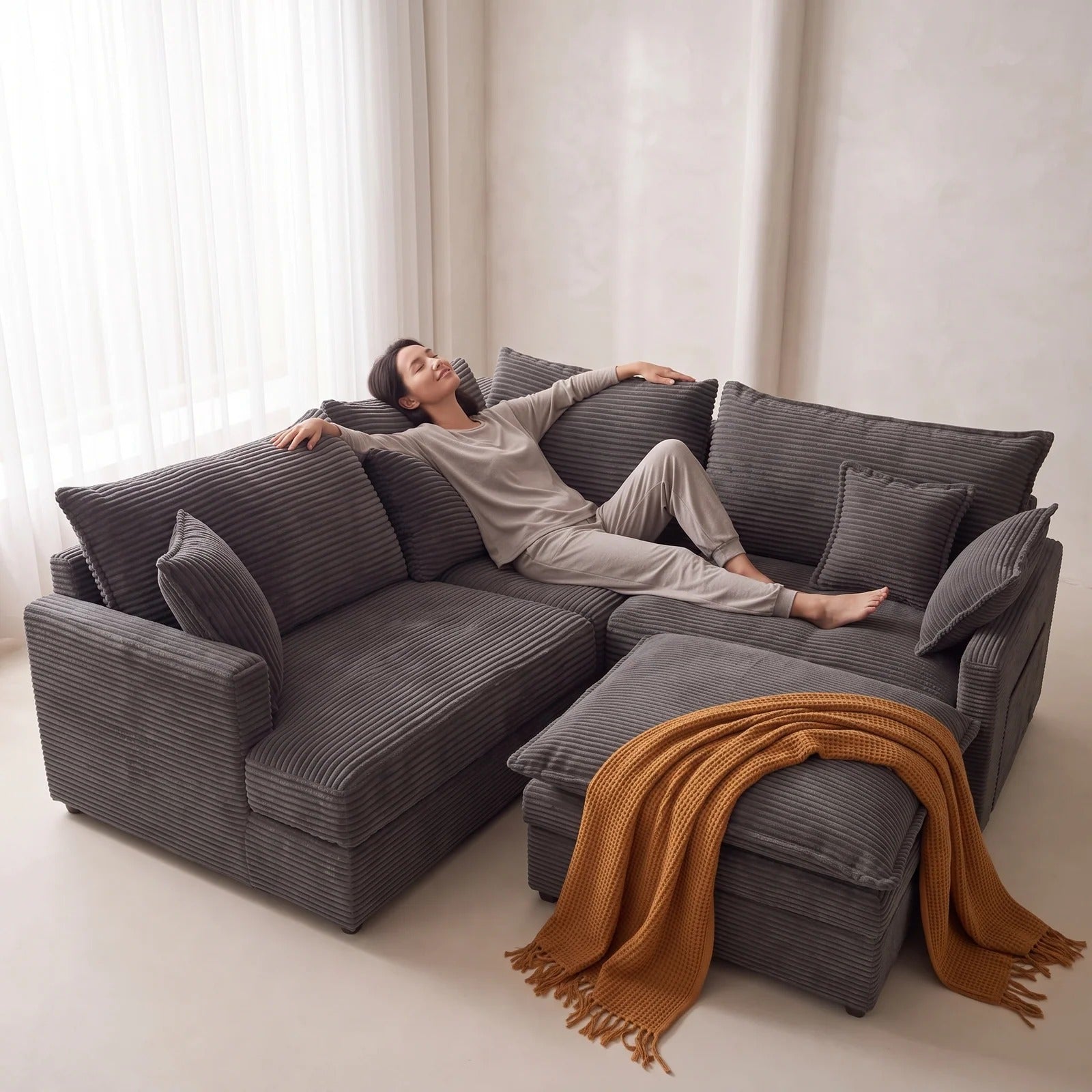 Woman relaxing on a charcoal grey modular sofa