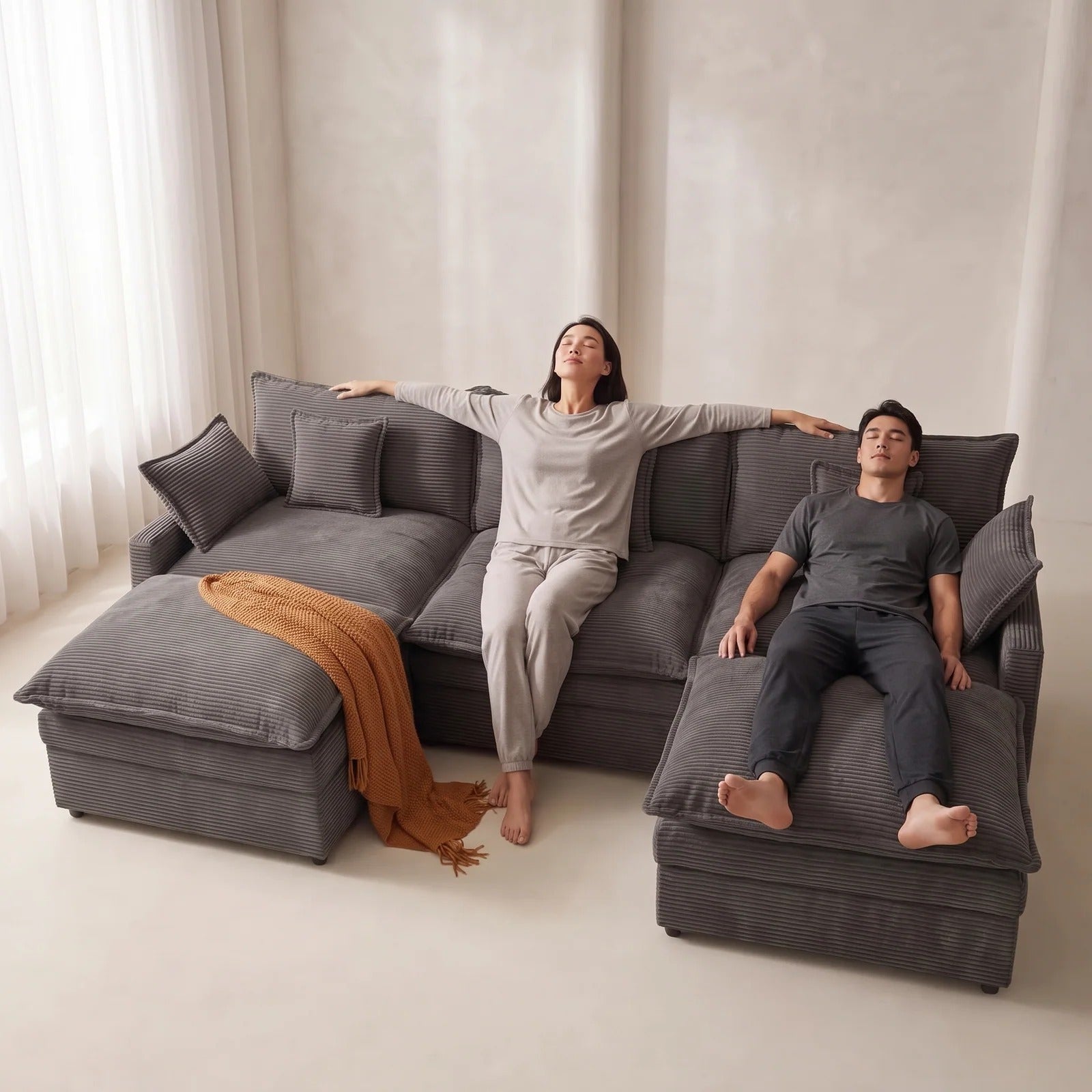 Couple relaxing on a spacious charcoal grey modular sectional sofa